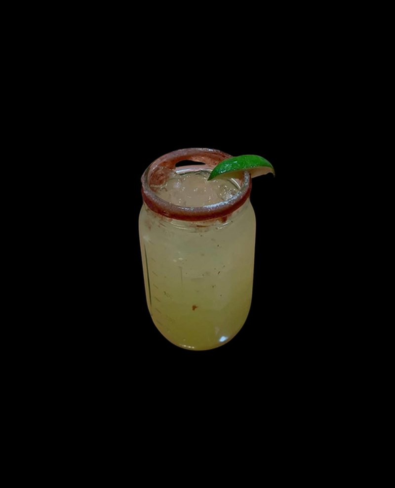 A house margarita in a jar-style glass with a lime wedge
